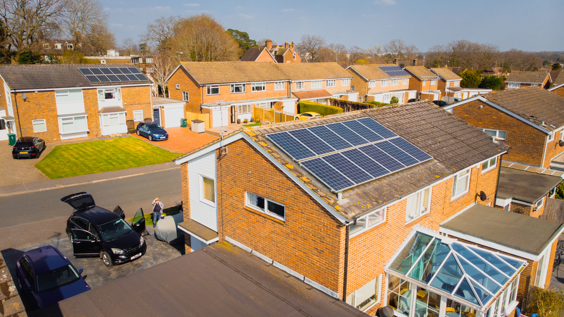 Aerial view, taken by drone, depicting the roof of a semi detached house on a residential street with solar panels installed.