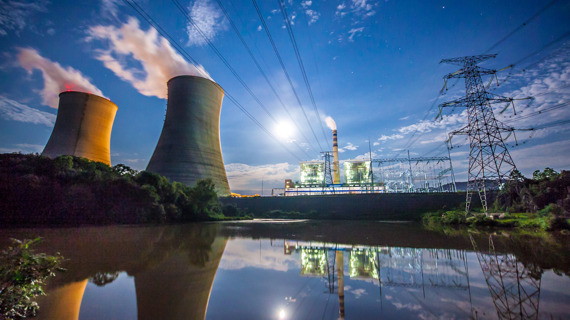 Two companies emitting smoke, with an electricgrid in the background