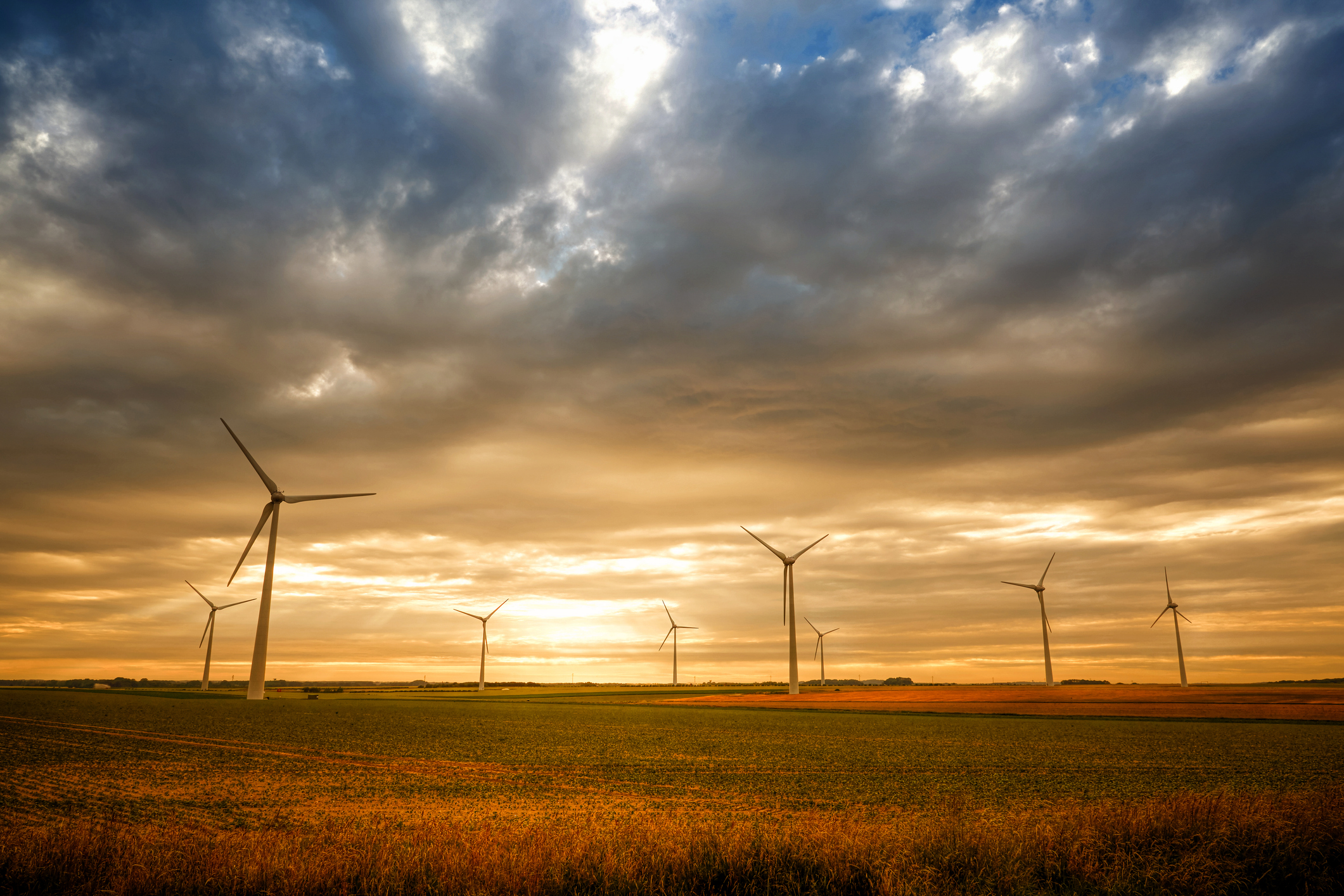 Wind turbines in a row against a sunset sky in the Calais region of France
